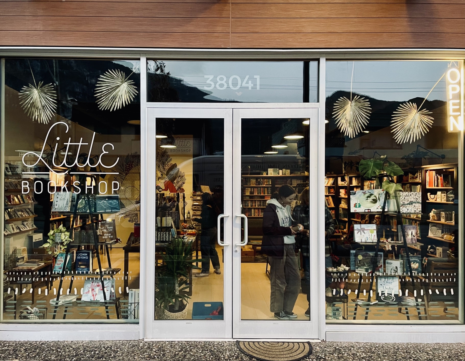 This is a photo of Little Bookshop's storefront in Squamish, B.C. There are shoppers inside talking to one another as they browse books.