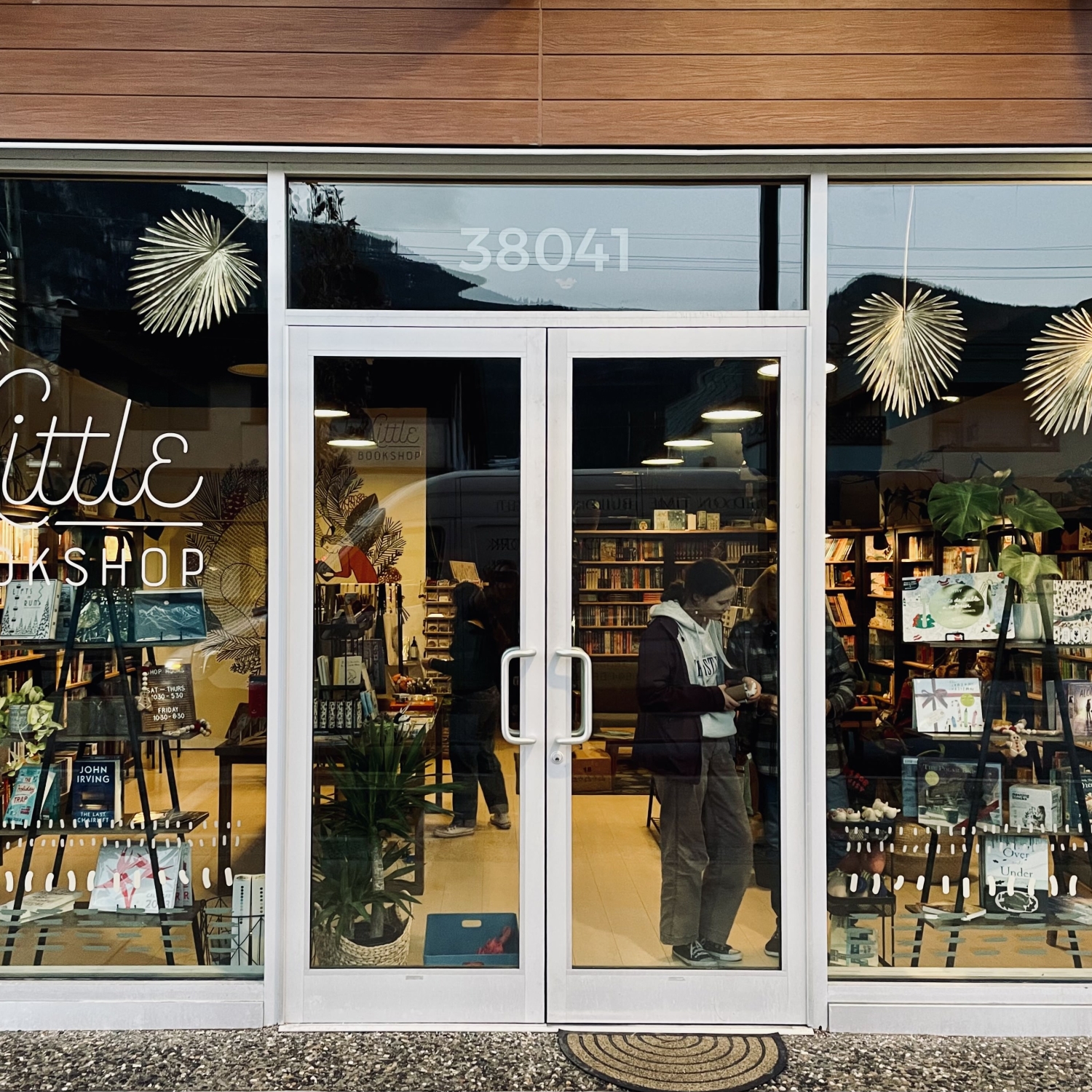 This is a photo of Little Bookshop's storefront in Squamish, B.C. There are shoppers inside talking to one another as they browse books.